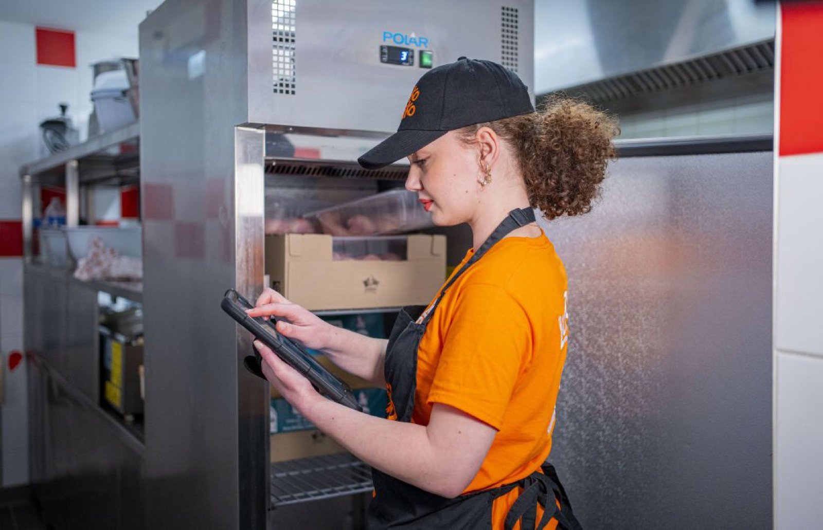 Équipière LokoRiko en cuisine préparant une commande sur tablette